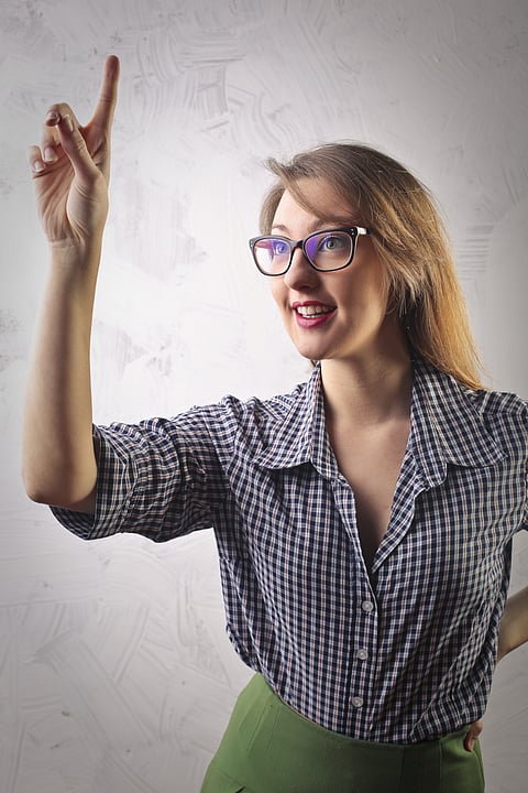 A woman excusing herself as she raises her finger 