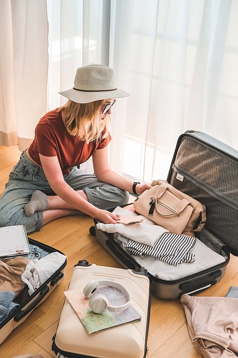 A woman tourist packs her essentials in separate bags