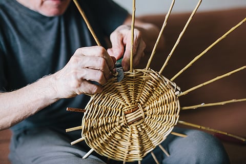 A man makes a wicker basket