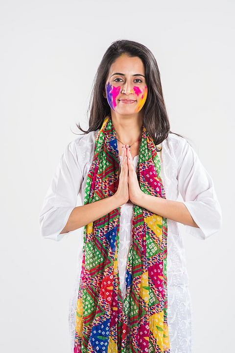 A girl wishes "Namaste" joining her palms together