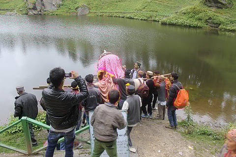 A procession carrying a palanquin with the local deity inside