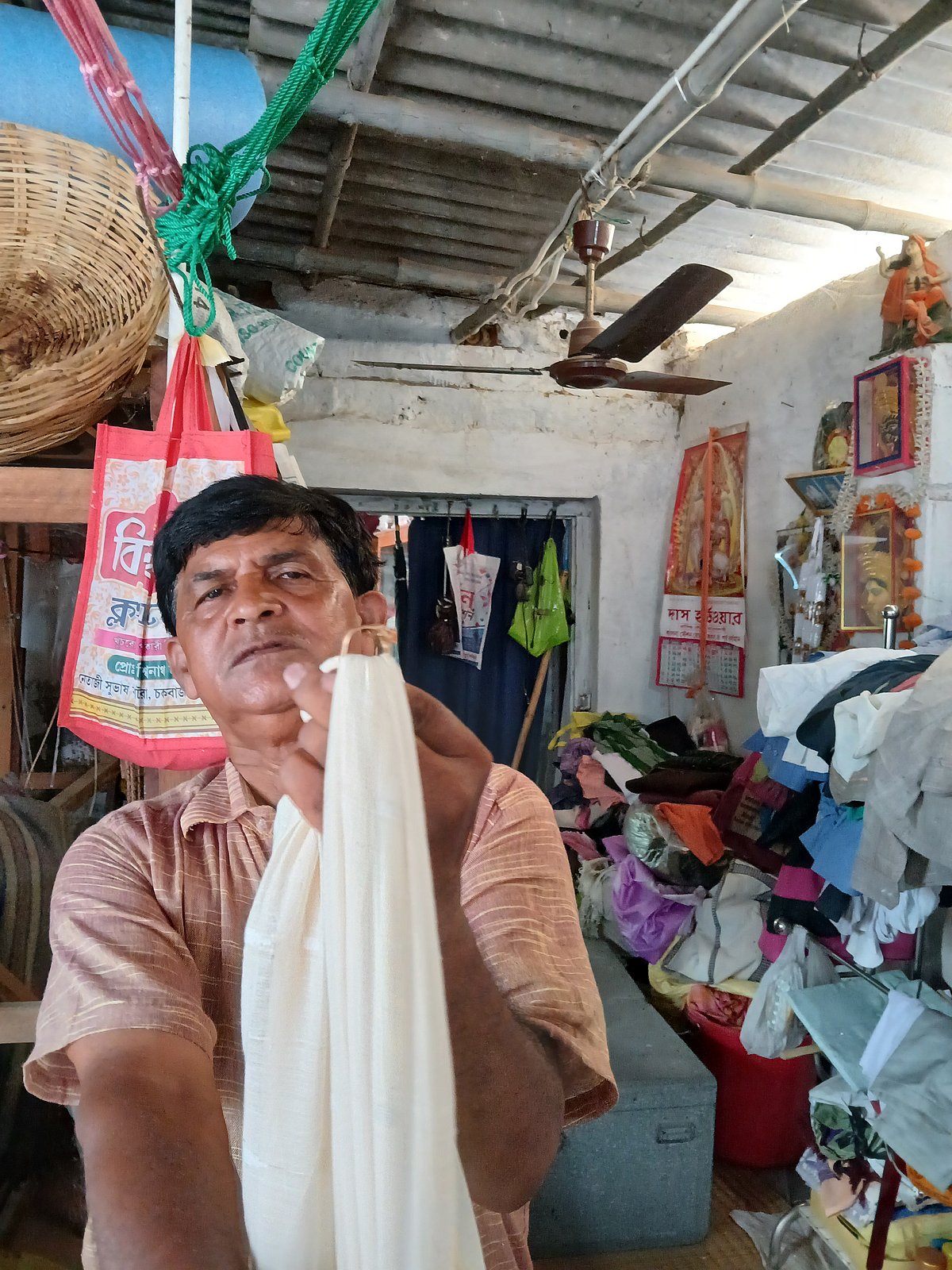 In his cramped workshop, Das proudly holds up his handiwork