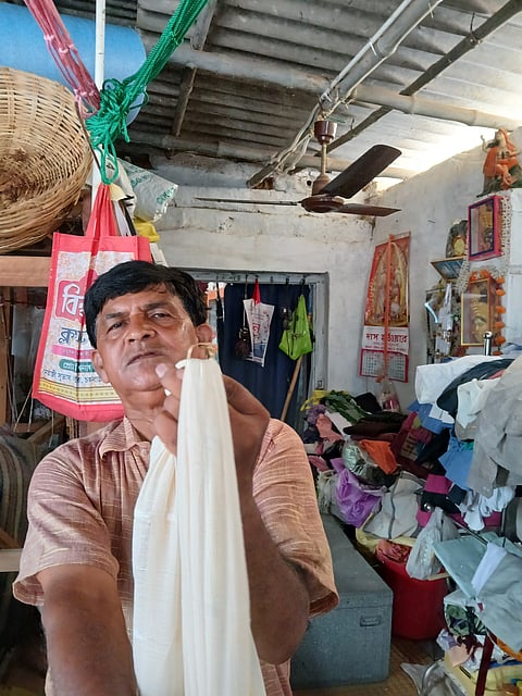 In his cramped workshop, Das proudly holds up his handiwork