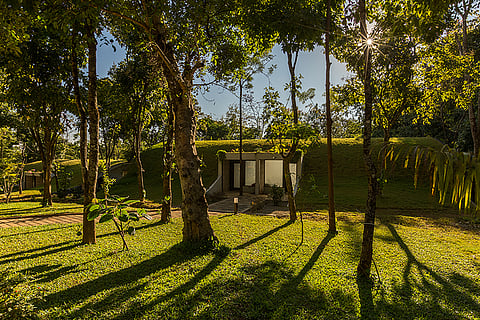 The buildings of Siri Nature Roost have curved, crescent-shaped roofs topped with local grass