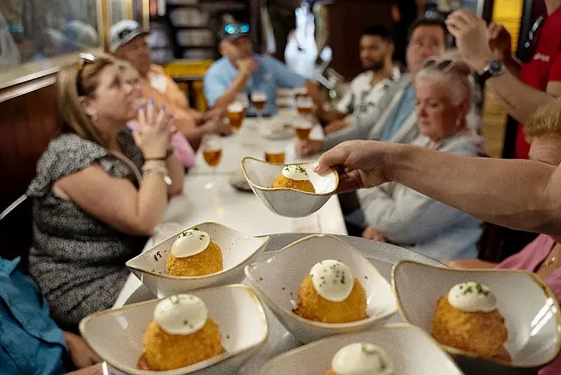 Tourists sit down for a meal as part of their Northern Spain culinary adventure