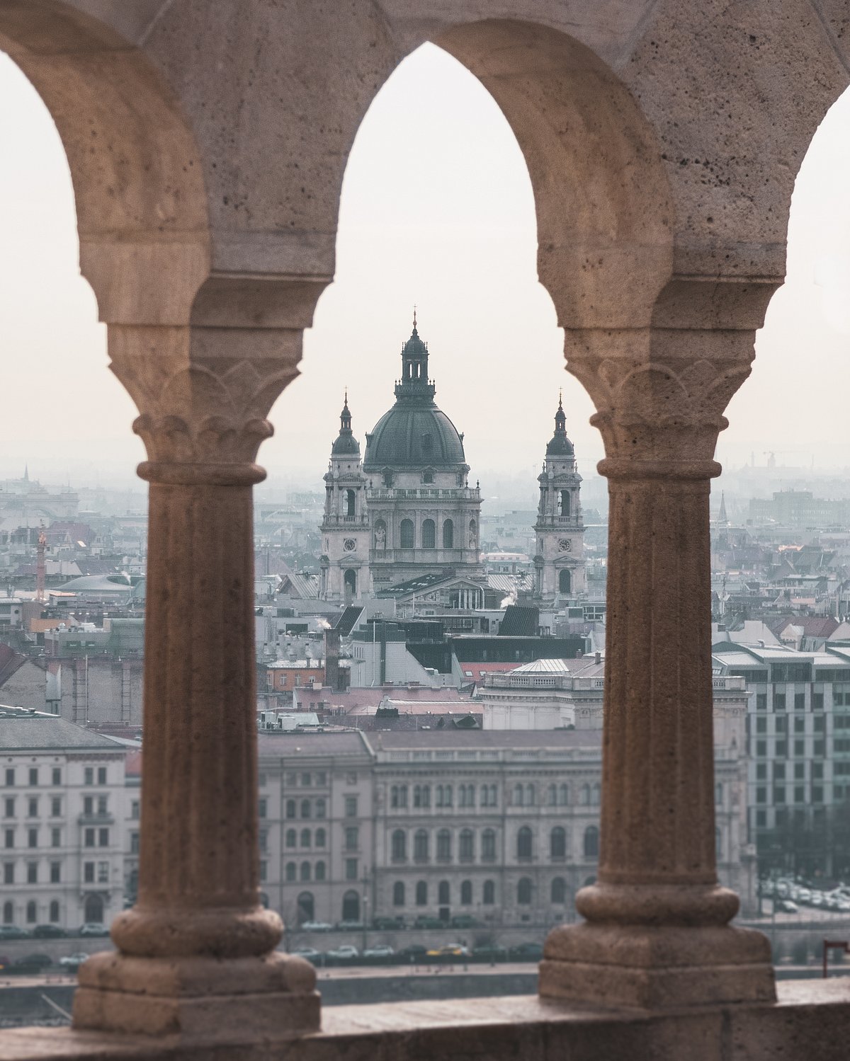 View of the St. Stephens Basilica from Buda hill looking through the arches of the Fishermans Bastion