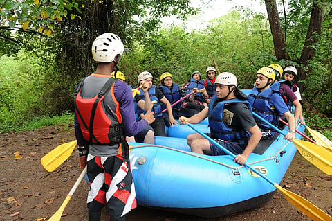 A guide gives instructions to paddlers before a river rafting session in Kolad