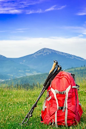 Shutterstock : Trekking with a backpack and trekking poles along the ridge in the mountains.