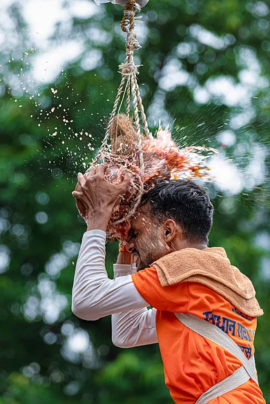 Shutterstock : A man breaks the dahi handi on Janmashtami