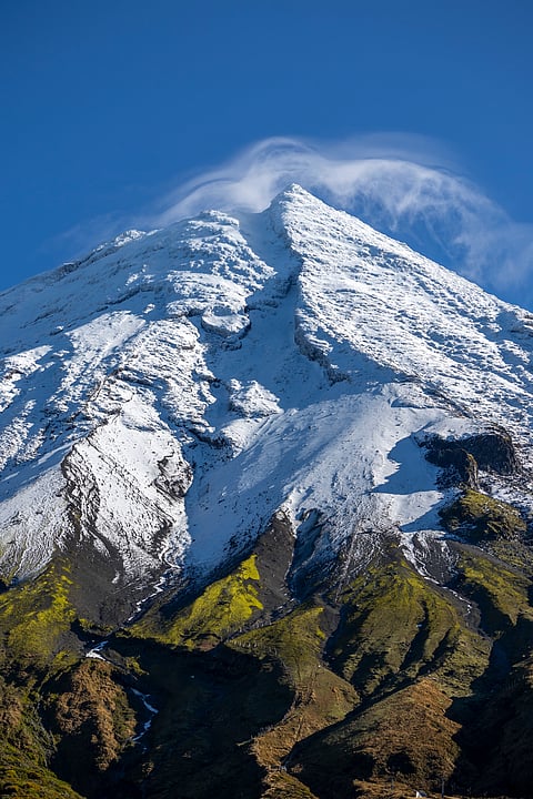 Mount Taranaki peak covered with snow and blue sky