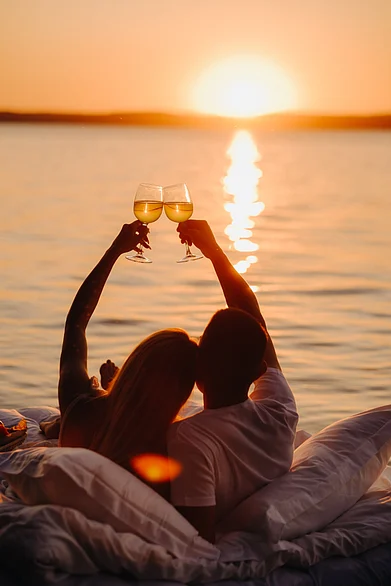 Shutterstock : A couple on their honeymoon drinks by the sunset