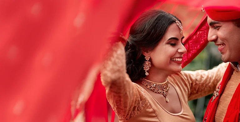 An Indian couple posing during their marriage - Shutterstock