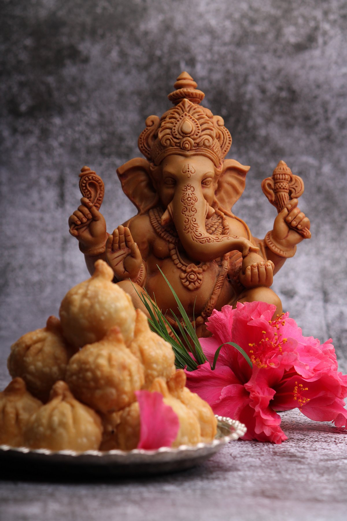 Shutterstock : Idol of Lord Ganesha with Modak in the foreground