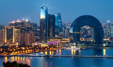 Rustamli Photos/Shutterstock : View of the Crescent Bay business center and Port of Baku from the upland park. Evening Baku Boulevard