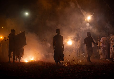 Men walk through firecracker smoke on the final night of the Phuket Vegetarian Festival in 2023
