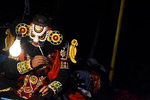 A yakshagana performer applies their make-up