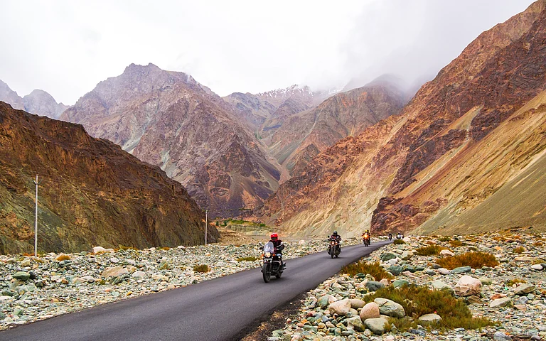 Bikers enjoying a beautiful scenic view between Diskit and Khardung La Pass in Nubra Valley - Shutterstock