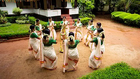 Thiruvathirakali dancers coordinate their hand movements as they clap upwards and downwards in a rhythm