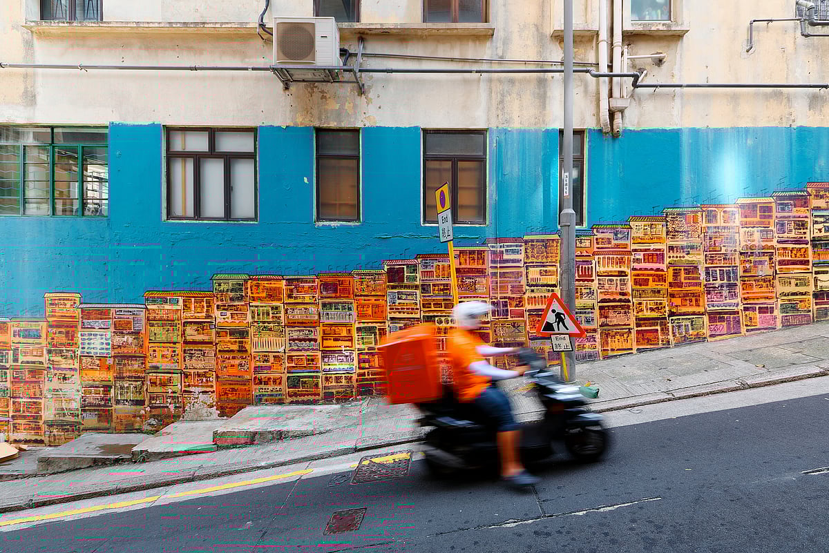 Shutterstock : A motorcycle courier zips past the Graham Street Wall Mural, an Instagram hotspot in Central District, Hong Kong.