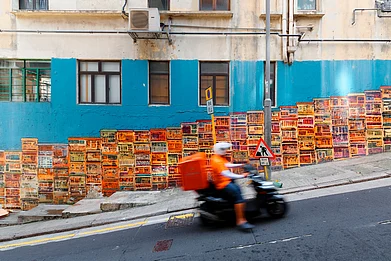 Shutterstock : A motorcycle courier zips past the Graham Street Wall Mural, an Instagram hotspot in Central District, Hong Kong.