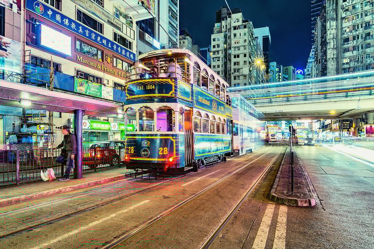 A retro tram glides through the evening city street, Hong Kong