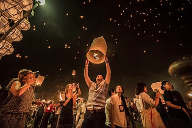 Theerayoot/Shutterstock : People release sky lanterns to worship Buddhas relics during the Yi Peng Festival in Chiangmai, Thailand