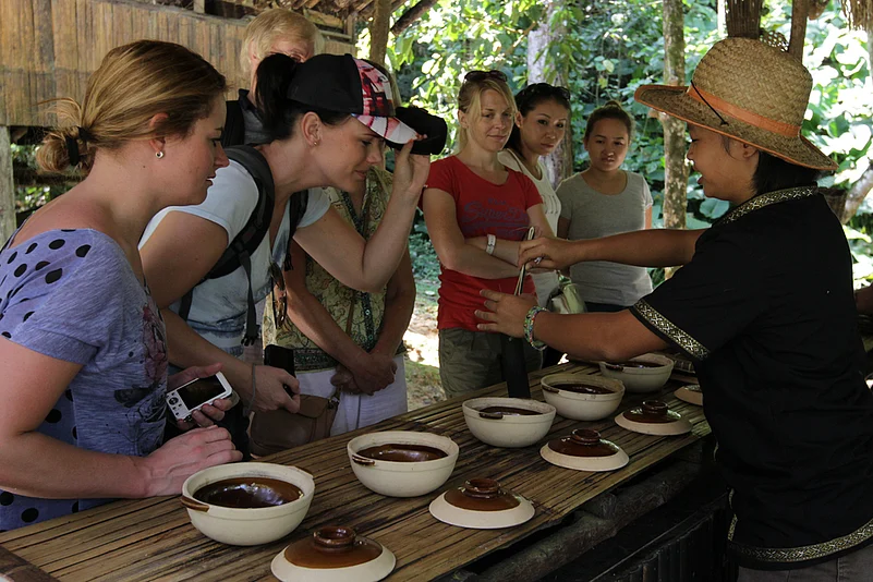 Tourists observe and learn from traditional food preparation workshops at Mari Mari Cultural Village in Malaysia
