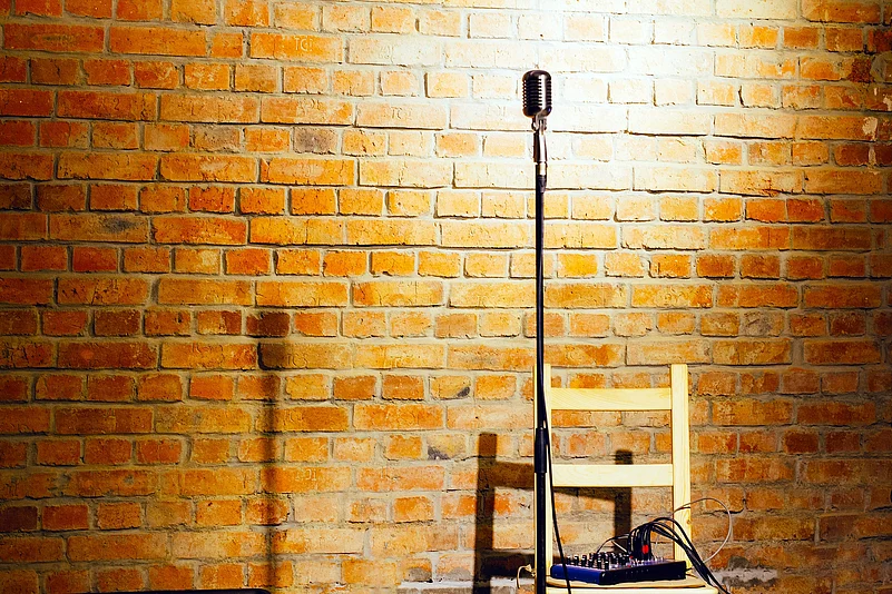 Microphone ready on stage against a brick wall