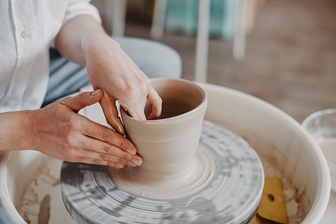 A person tries their hands on pottery