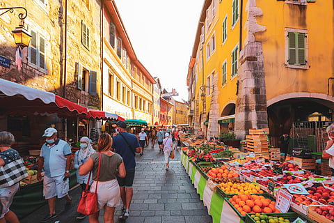 Morning street market vendors with fresh vegetables and fruits in Annecy