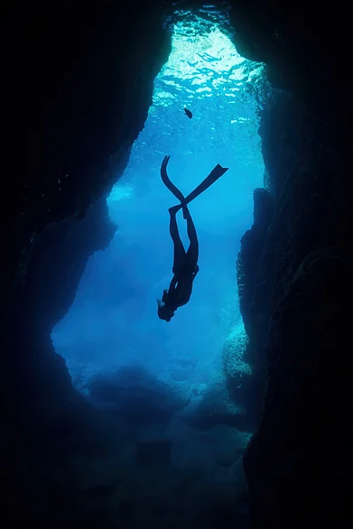 Shutterstock : A woman diving inside a cave