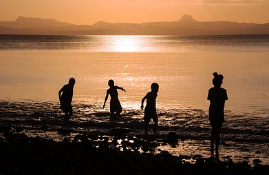 Renee Vititoe/Shutterstock : Children play at a beach in Savusavu, Fiji