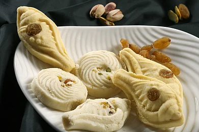 Shutterstock : Assorted sweets as prasad is distributed at the Saraswati puja in West Bengal