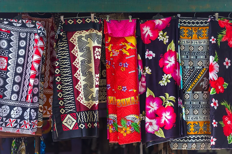Multi-coloured fabrics for sale at a local market in Fiji - gg-foto/Shutterstock