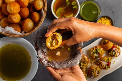 Shutterstock : A person enjoys authentic Marathi pani puri