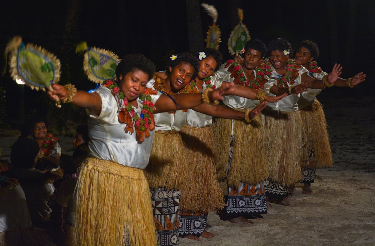 Fijian women perform the traditional fan dance (meke) during a vibrant cultural night show
