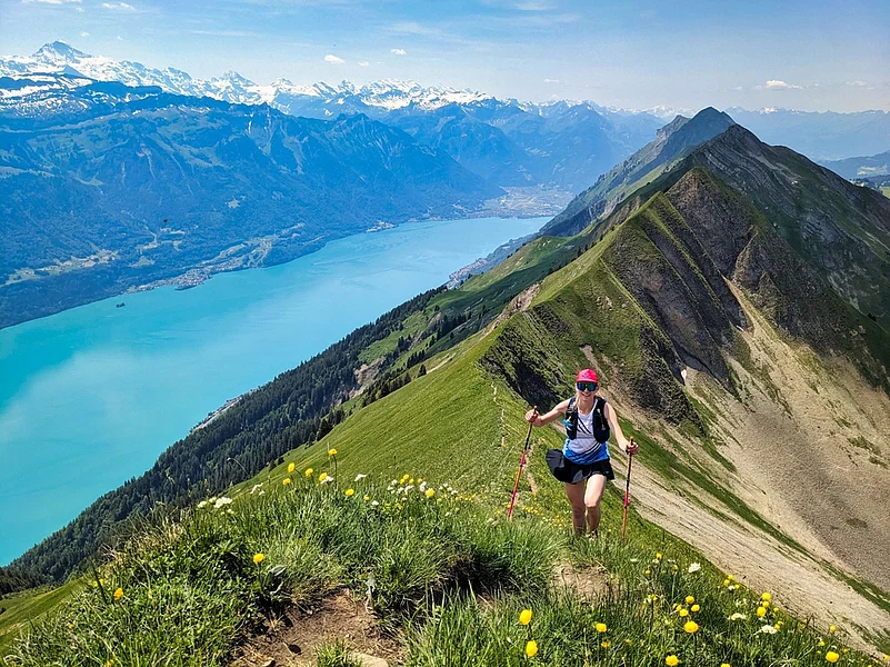A young woman runs over the Hardergrat above Lake Brienz