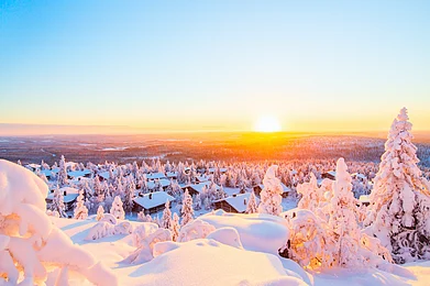 BlueOrange Studio/Shutterstock : Sunset view over wooden huts and snow in Finnish Lapland