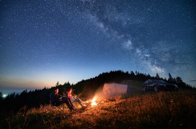 Shutterstock : Enthusiasts night camping in the mountains under starry sky with Milky way