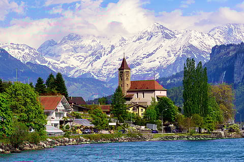 Brienz town on Lake Brienz by Interlaken, with snow covered Alps mountains in background