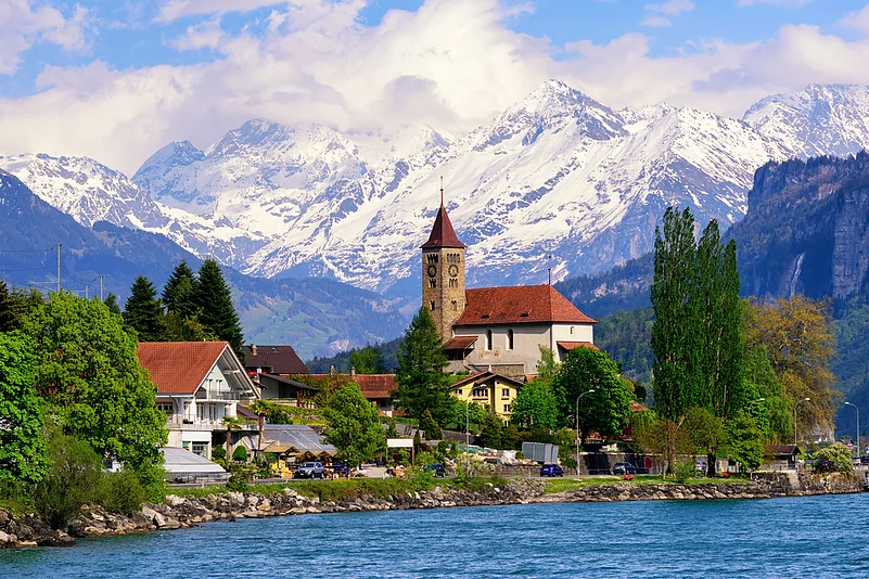 Brienz town on Lake Brienz by Interlaken, with snow covered Alps mountains in background