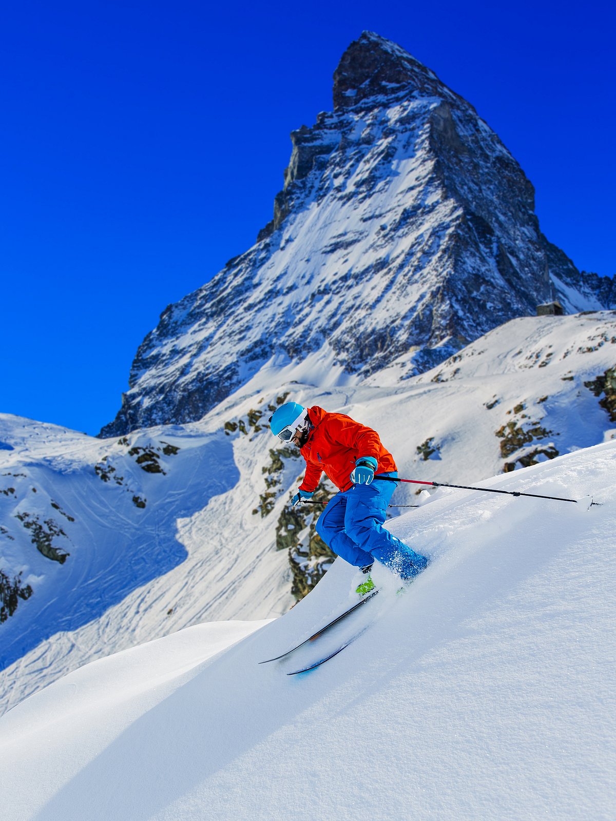 Shutterstock : Man skiing in deep fresh powder snow with Matterhorn in background in Swiss Alps