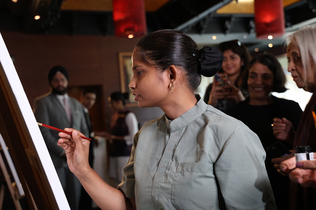 Several visually impaired women from the National Association for the Blind India’s Centre for Blind Women and Disability Studies painted on a canvas with Anjolie Ela Menon