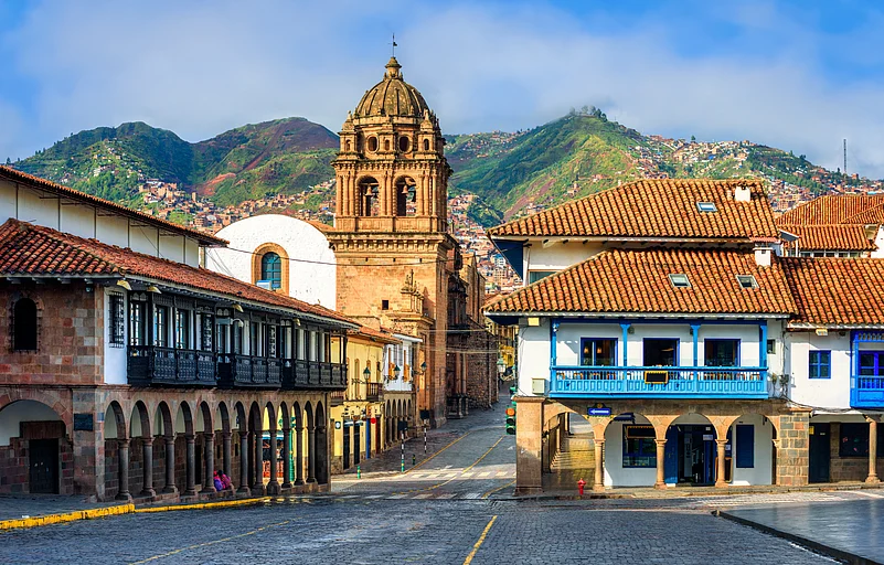 View of Plaza Mayor and the Basilica Menor in Cusco’s Old Town, framed by the Andes mountains