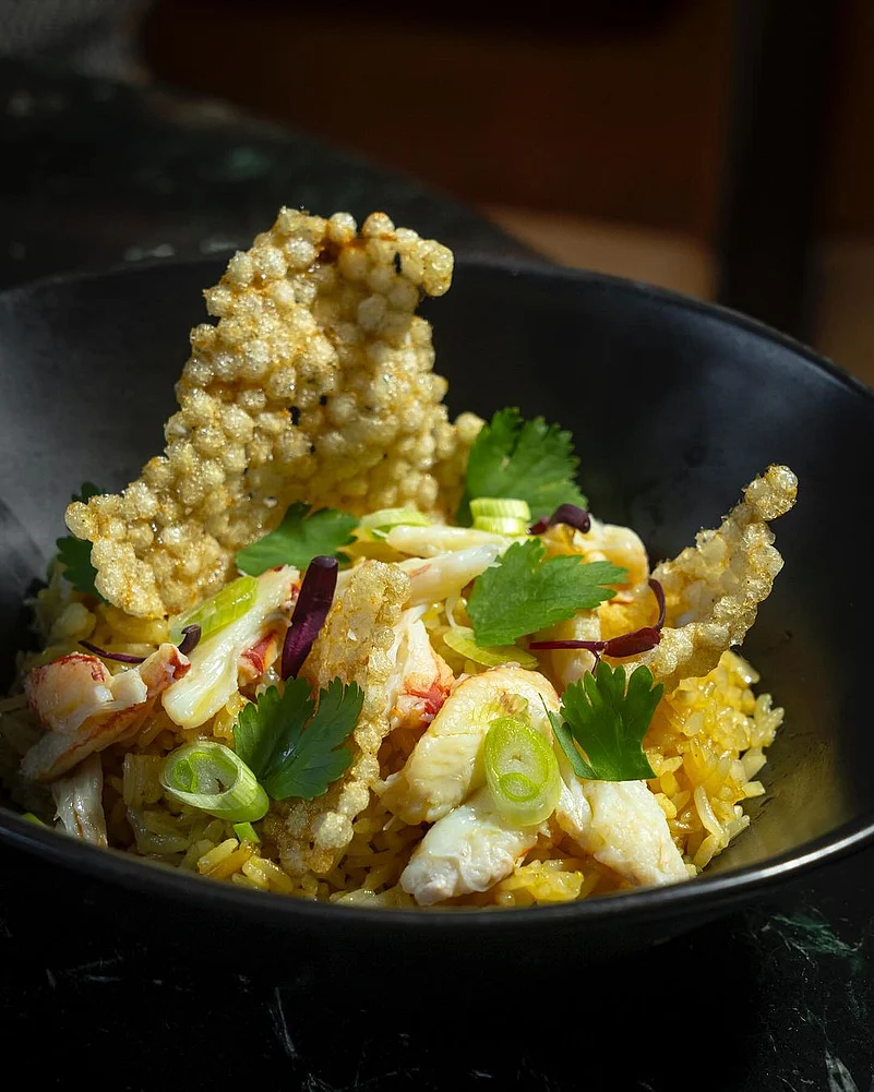 A bowl of Peekytoe Crab Fried Rice with Kerupuk to add some crunch