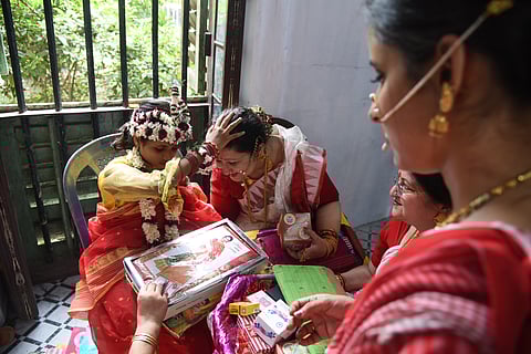The girl child, who is the embodiment of the goddess Durga, gives her blessings to a devotee