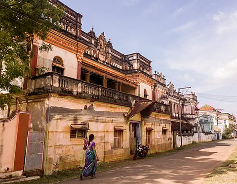 An old, grand mansion with weathered walls and vintage architecture in a village in Chettinad