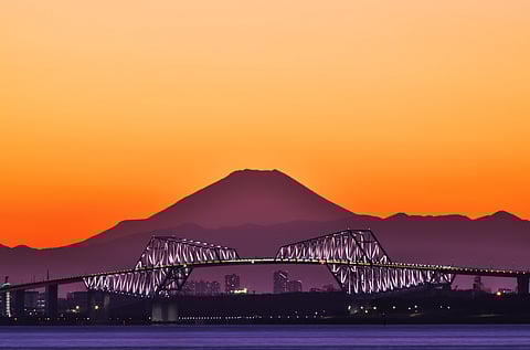 Sunset colours over Mount Fuji and and Tokyo Gate Bridge as seen from Urayasu