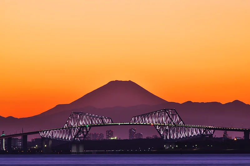 Sunset colours over Mount Fuji and and Tokyo Gate Bridge as seen from Urayasu