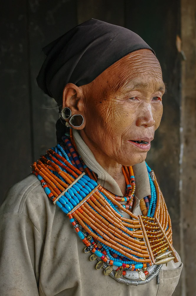 Portrait of old Naga Konyak tribe woman wearing traditional necklace and earrings